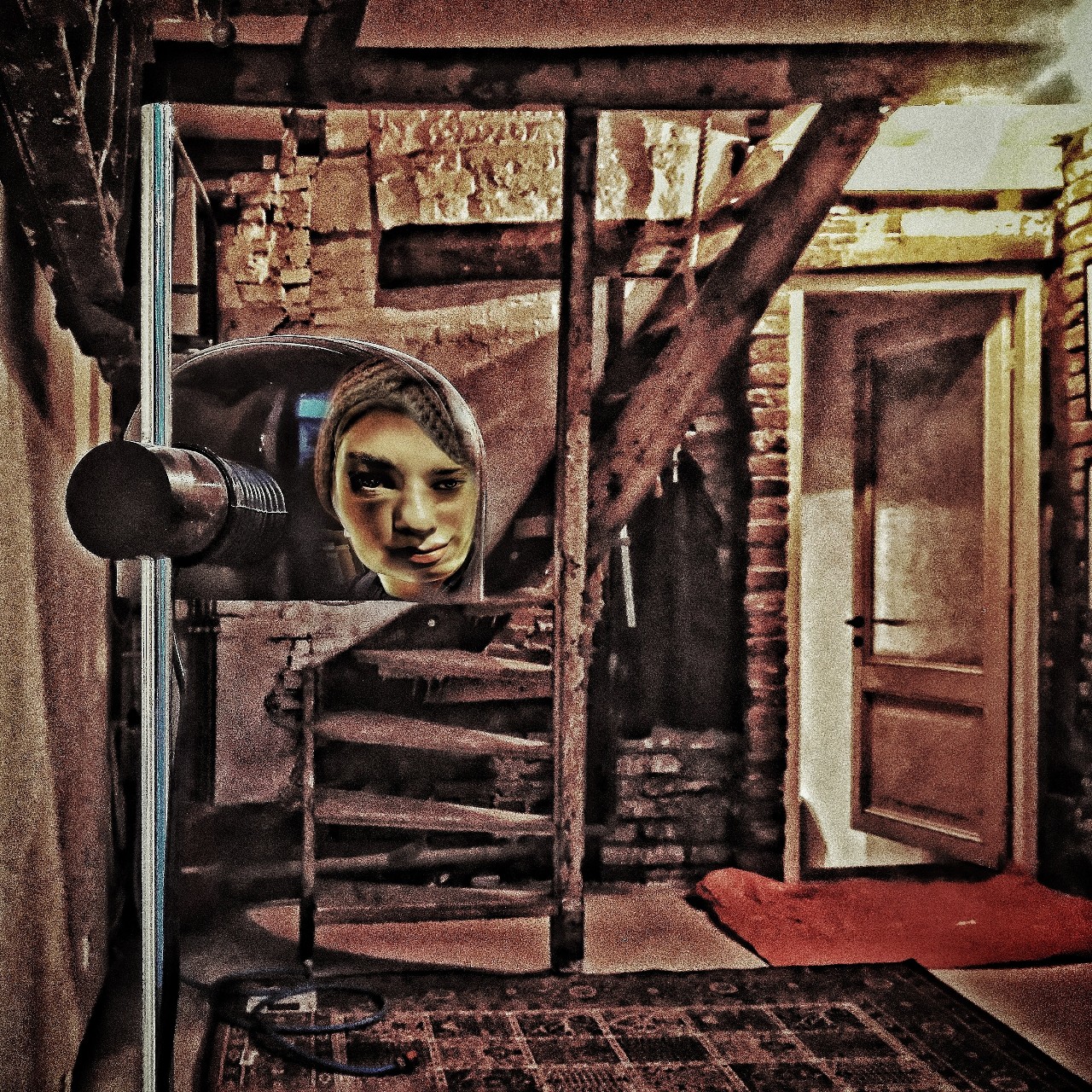 Het portret van een vrouw in weerspiegeling in een lampenkap in een leeg interieur. Bijna als een schilderij